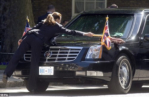 The smartly dressed driver of the President's vehicle brushes down its shiny exterior as she waits for him outside the Prime Minister's residence